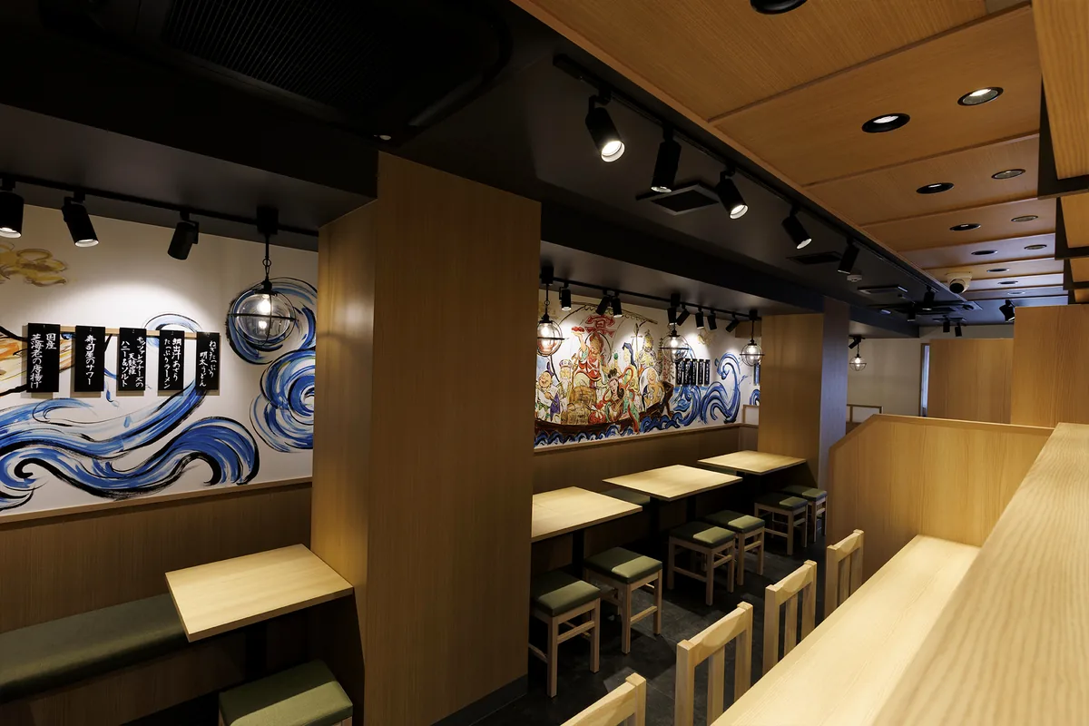 木のテーブル席が並ぶ明るい店内